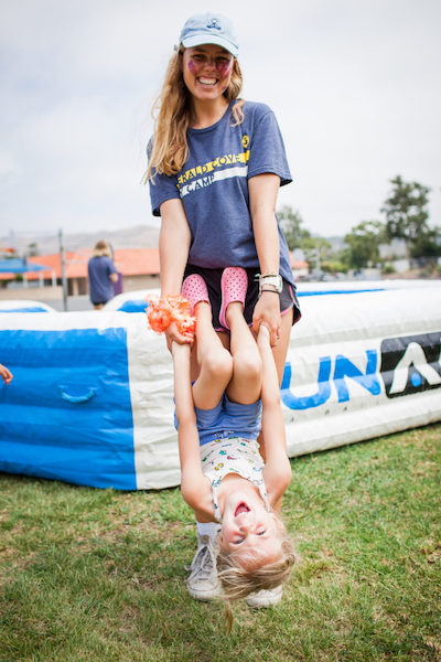 camp counselor holding a camper upside down
