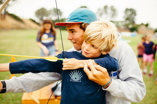 Kid shooting bow and arrow with Summer staff